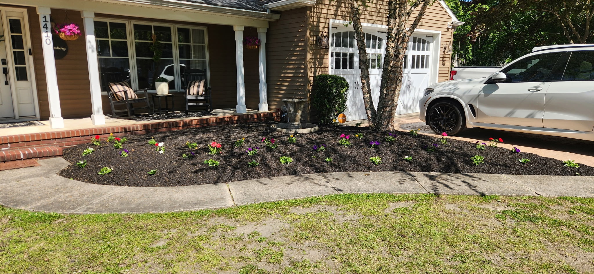 Fresh mulch bed with colorful flower plantings in front yard