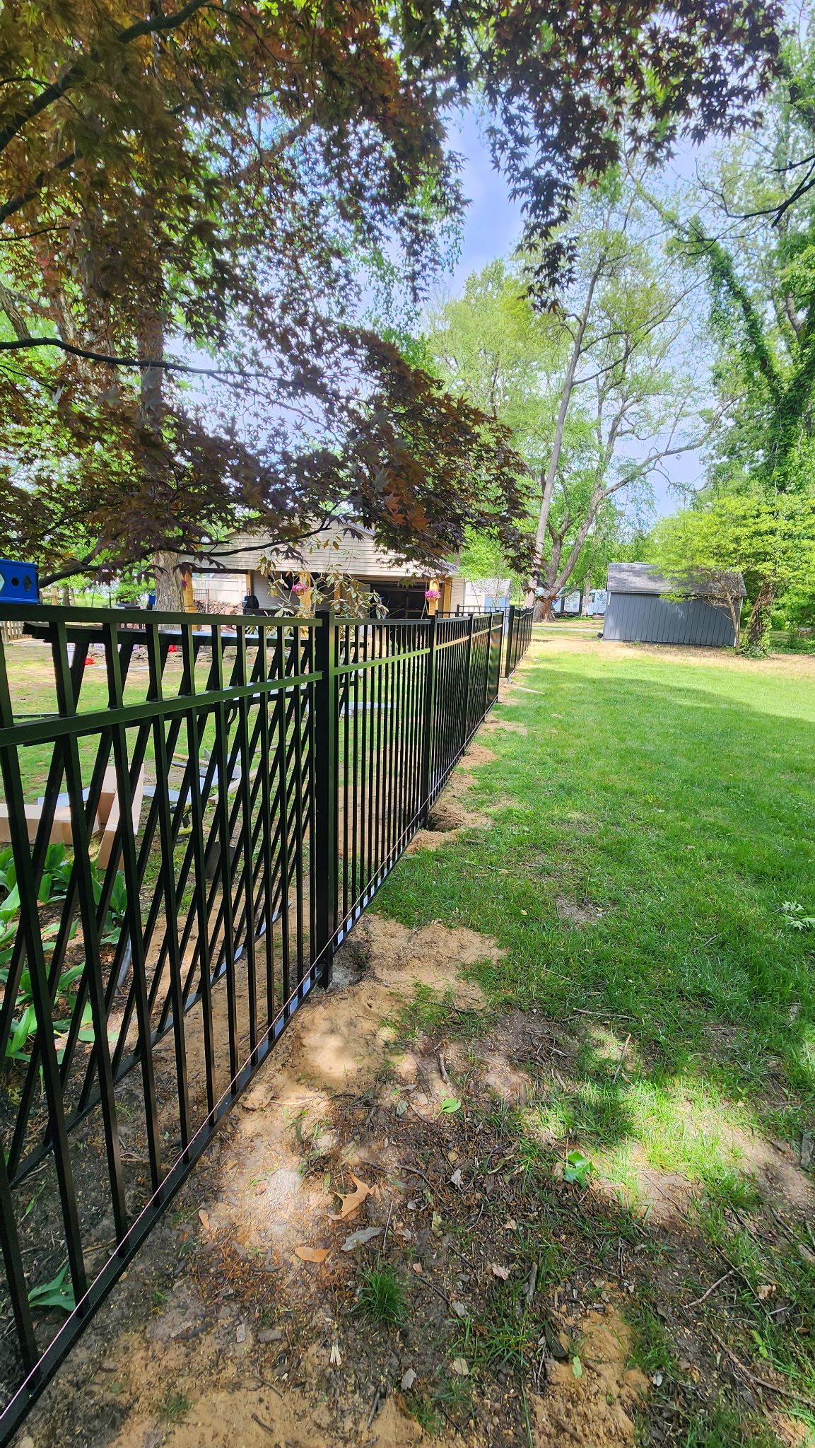 Black aluminum fence installation with lawn