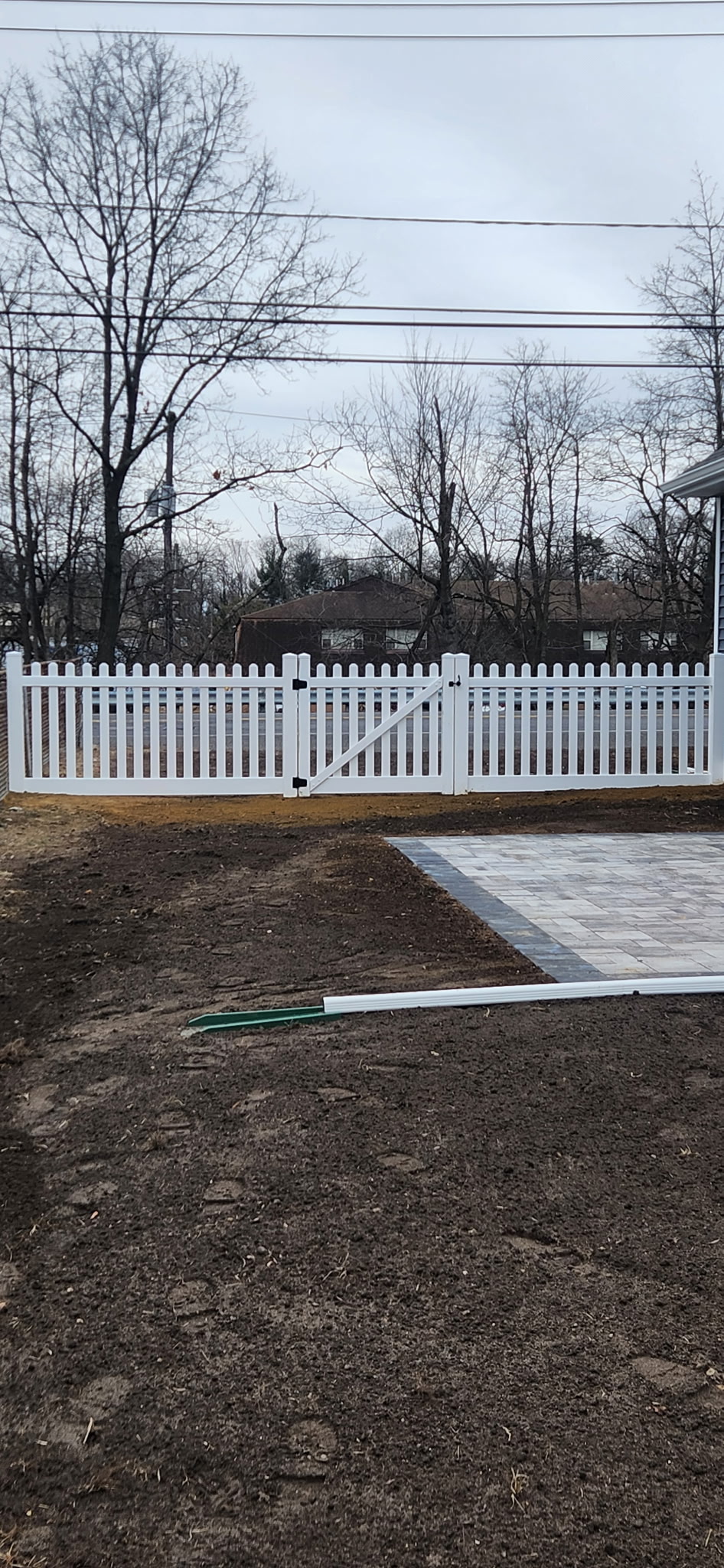 White picket fence with paver patio area