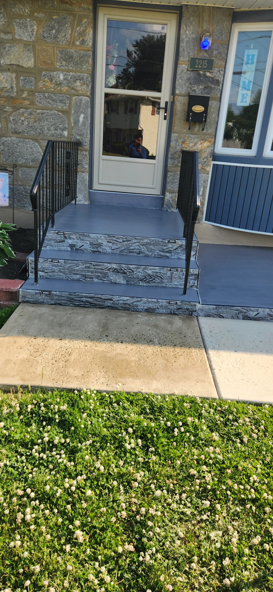 Front steps with stone veneer and railing