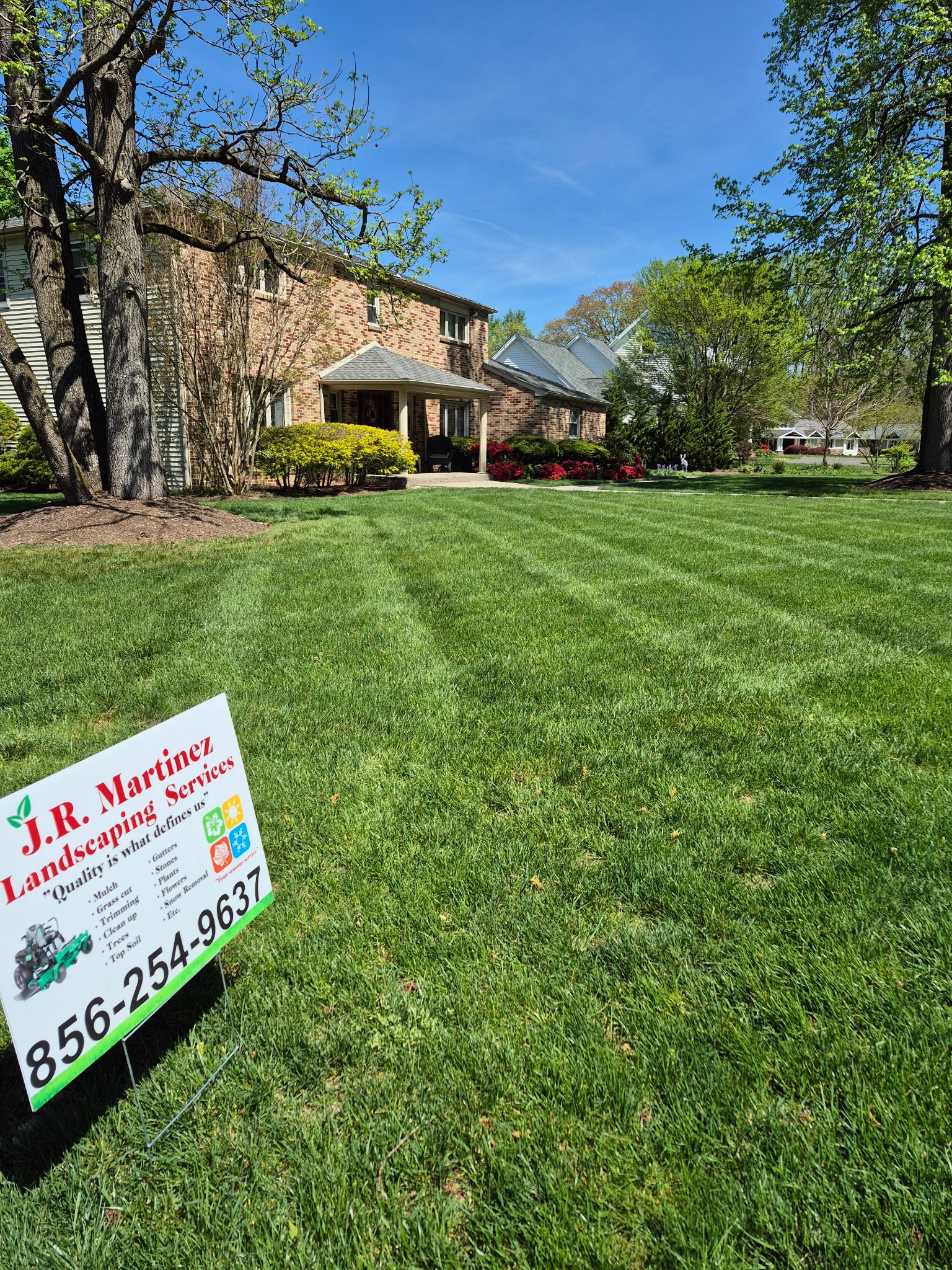Striped lawn with J.R. Martinez Landscaping yard sign