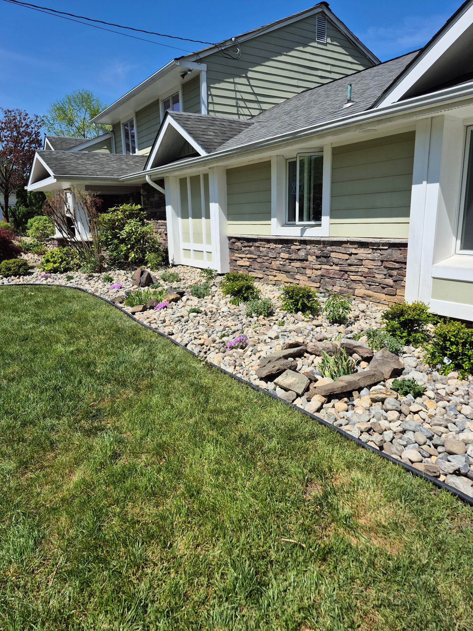 Rock garden with plantings along house foundation
